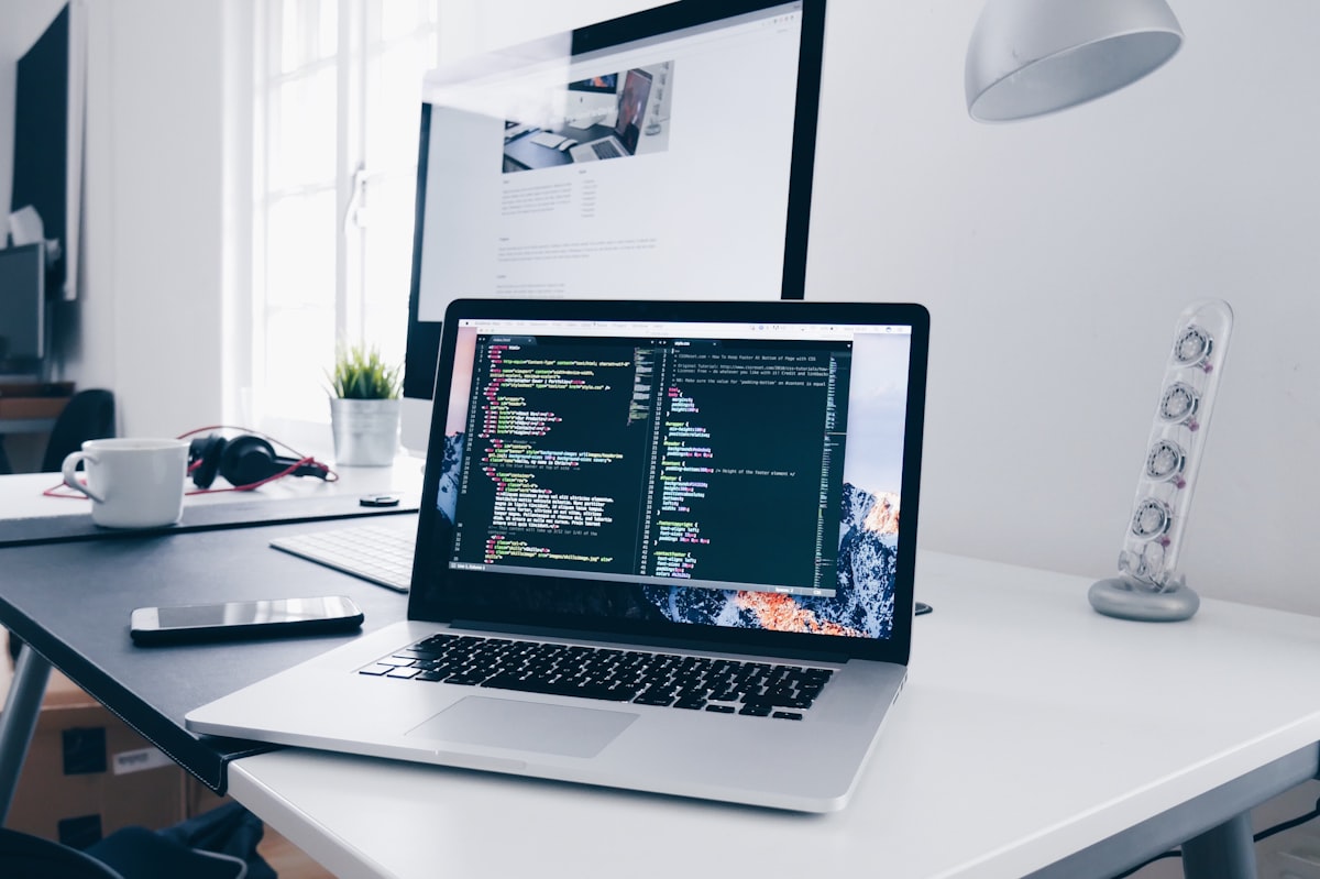Aufgeräumter Arbeitsplatz mit Laptop, an dem Webseiten entstehen
